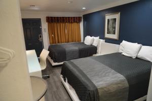 a hotel room with two beds and a table at Flamingo Inn in Rosemead