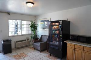 a room with a refrigerator filled with drinks and a chair at Flamingo Inn in Rosemead