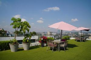 una mesa y sillas con una sombrilla en el techo en Luxury Skynest with Gym and Pool in Westlands, en Nairobi