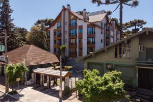 a large apartment building with a gazebo in front at Residencial Lumiére 2 dorm by Achei in Canela