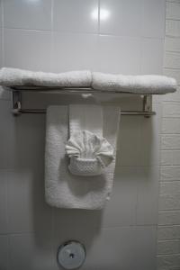 a towel hanging from a shelf in a bathroom at Flamingo Inn in Rosemead +39 photos