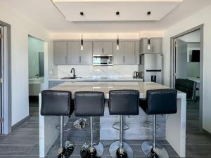 a kitchen with a large island with black bar stools at Apt Four A #4 in Punta Penasco New