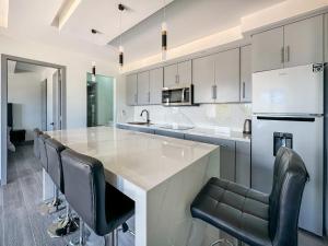 a kitchen with a large island with black chairs at Apt Four A #4 in Punta Penasco New