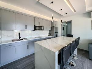 a kitchen with white cabinets and a large marble counter at Apt Four A #4 in Punta Penasco New +12 photos