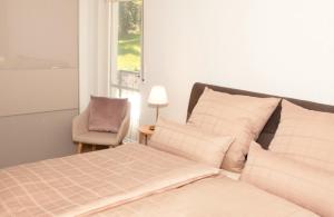 a bedroom with a bed and a chair and a window at Sonnenterrasse 9 in Fischerbach