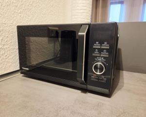 un four micro-ondes installé au-dessus d'un comptoir dans l'établissement Ferienwohnung Krone - nähe Europa-Park, Rulantica, Triberg, à Lahr/Schwarzwald