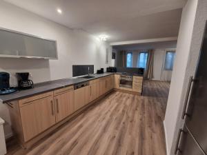 une grande cuisine avec des armoires en bois et un plancher en bois dans l'établissement Ferienwohnung Krone - nähe Europa-Park, Rulantica, Triberg, à Lahr/Schwarzwald 3 autres photos