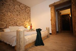 a bedroom with a bed with a wall made of logs at Domek Rochowa Buźnica apartament 2 in Zakopane