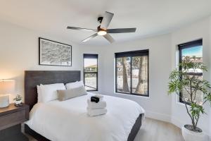 a bedroom with a white bed with a ceiling fan at 4 Mi to Dtwn Luxe Gem with Pool in Lake Havasu City in Lake Havasu City +31 photos