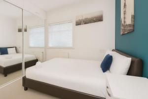 ein Schlafzimmer mit zwei Betten und einem Spiegel in der Unterkunft Stylish 4-Bedroom Home with Modern Comforts in Derby + 2 Fotos