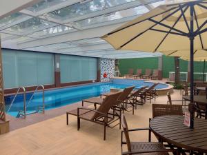a pool with tables and chairs next to a swimming pool at Barbosa Studios - Verbo Divino in Sao Paulo