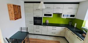 a kitchen with white cabinets and a green wall at Clonakilty Holiday Home in Clonakilty