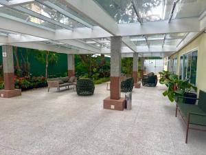 a lobby with chairs and plants in a building at Barbosa Studios - Verbo Divino in Sao Paulo