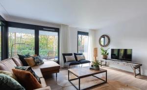 Una sala de estar con un sofá y un televisor. en Villa Nami, en Denekamp