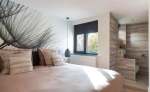 Un dormitorio con una cama grande y una ventana grande en Villa Nami, en Denekamp