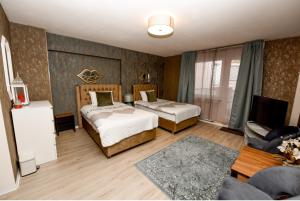 ein Hotelzimmer mit zwei Betten und einer Couch in der Unterkunft Haus Thomas Deluxe 3 in Dortmund