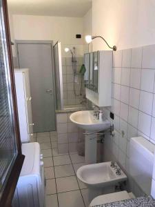 a white bathroom with a sink and a toilet at Ca' del Maharajà in Gargallo +14 photos