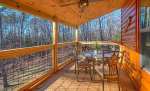 a screened in porch with a table and chairs at The Fawn at Deer Ridge in Murphy