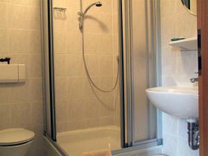 a bathroom with a shower and a toilet and a sink at Hotel Haus Niggemann in Hattingen