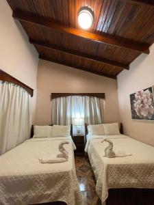 twee bedden in een kamer met twee zwanen erop bij Hostal Marias in Copan Ruinas