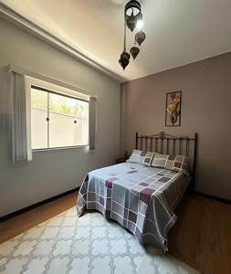 a bedroom with a bed and a window at Flat Funcional Moderno | Conforto e Praticidade in Nova Friburgo