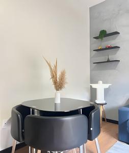 a dining room with a black table and black chairs at Flat Funcional Moderno | Conforto e Praticidade in Nova Friburgo