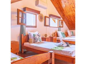 a room with two beds and two windows at Le Mohana - L'évasion tropicale de l'Est in Saint-André