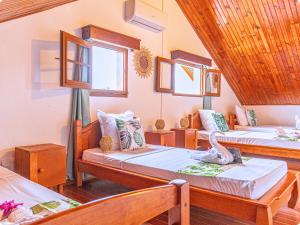 a room with two beds and two windows at Le Mohana - L'évasion tropicale de l'Est in Saint-André +13 photos
