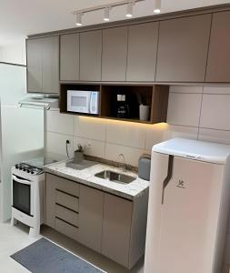 eine weiße Küche mit Spüle und Mikrowelle in der Unterkunft Mel Prime Loft in Extrema