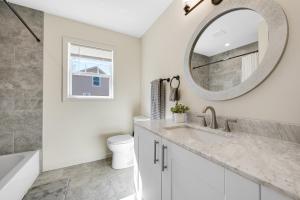 a white bathroom with a sink and a mirror at Amazing Entire Townhouse Sleeps 20 Group Favorite in Bloomfield +52 photos