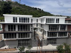 a white building with a hill in the background at Villa Palma in Tbilisi City