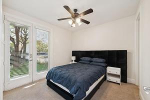 une chambre avec un lit et un ventilateur de plafond dans l'établissement Highland Park, Oak Lawn Dallas Townhome, à Dallas