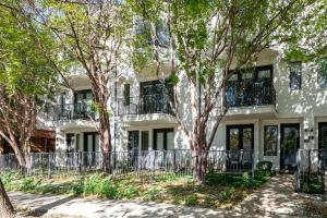 un bâtiment blanc avec des arbres devant dans l'établissement Highland Park, Oak Lawn Dallas Townhome, à Dallas