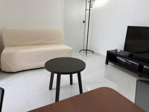a room with a table and a couch and a stool at A Cozy Loft for You in Conflans-Sainte-Honorine +1 photo