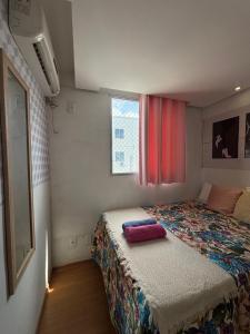 een kleine slaapkamer met een bed met een kleurrijke quilt bij Recanto do Sol, 2 quartos, piscina ambiente tranquilo in Recife +51 foto's