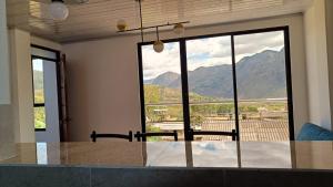 a dining room with a view of mountains through a window at Amaru 