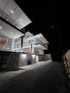 a large white building at night with its lights on at Villa Palma in Tbilisi City