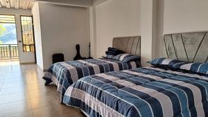 two beds sitting in a room with at Amaru  +1 photo