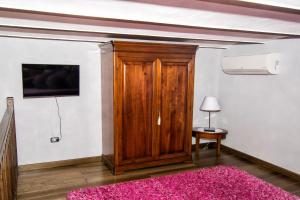 a room with a wooden door and a pink rug at B&B Casa Dilillo in Foggia
