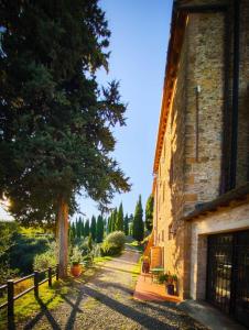 a house with a tree next to a building at Rocca degli Olivi in San Gimignano