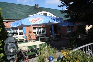 a patio with a table and an umbrella at Teschendorfer Landgasthof in Teschendorf