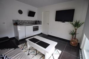 a white living room with a tv and a white table at Cocon douceur in Gingsheim