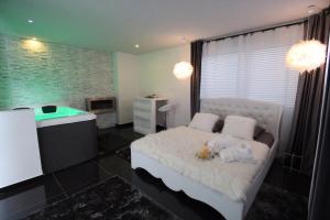 a bedroom with a white bed and a tub at Cocon douceur in Gingsheim