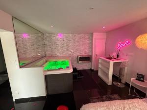 a room with a pool table in a room with pink lights at Cocon douceur in Gingsheim