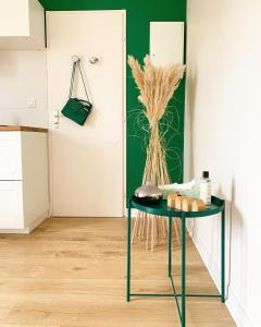 Una mesa verde con un jarrón de hierba seca en Cocooning appartement, en Joué-lès-Tours