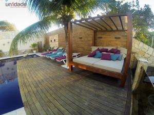 a bed on a wooden deck next to a swimming pool at Casa Colina Pipa in Pipa +34 photos