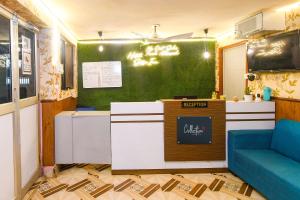 KhandagiriHotel O Sawan INN的一间设有柜台和绿色墙壁的餐厅