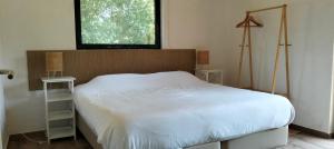 a bedroom with a white bed and a window at Casa da Mata in Praia de Mira