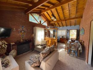 ein Wohnzimmer mit Sofa und Tisch in der Unterkunft Alma del Bosque PILETA E HIDROMASAJES Semiclimatizados in Mar Azul