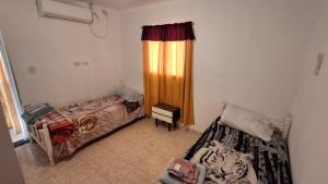 a room with two beds and a window with a curtain at Residencial Boveda in Aimogasta